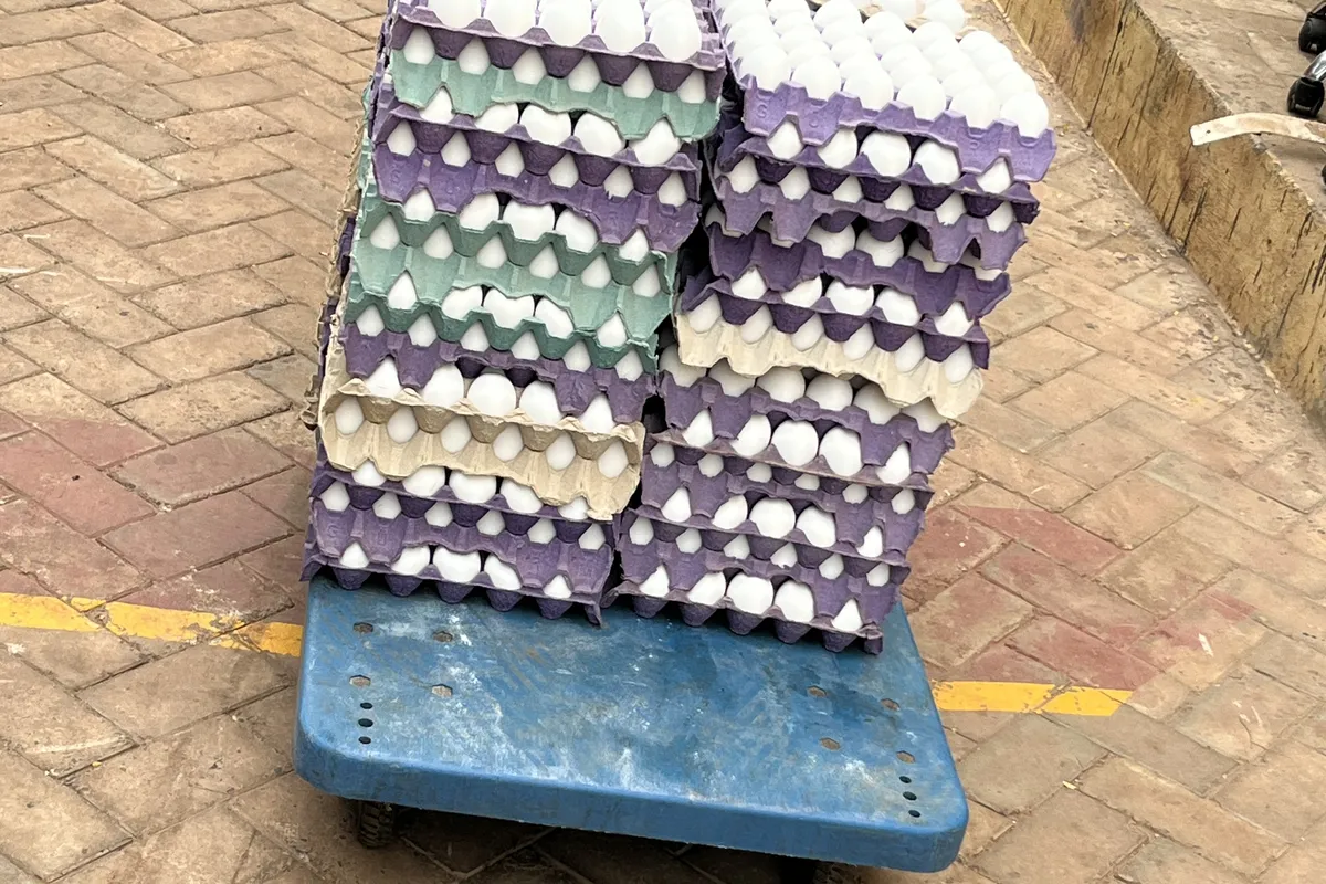 Egg crates stacked at scale on a delivery trolley